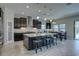 Modern kitchen featuring an island with seating, dark wood cabinets, and stainless appliances at 11222 Hawks Fern Dr, Riverview, FL 33569