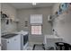 Efficient laundry room equipped with modern washer, dryer, and utility sink at 11222 Hawks Fern Dr, Riverview, FL 33569