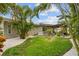 Serene backyard with lush greenery, white rock landscaping, and a cozy outdoor patio area at 113 16Th St, Belleair Beach, FL 33786