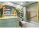 Charming bathroom featuring a colorful vanity, decorative mirror, and coordinated shower curtain at 113 16Th St, Belleair Beach, FL 33786