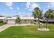 Charming single-story home with a well-manicured lawn, white roof, and a bright yellow front door at 113 16Th St, Belleair Beach, FL 33786