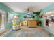 Bright living room with turquoise walls, casual seating, and tropical decor creates a relaxed, inviting space at 113 16Th St, Belleair Beach, FL 33786