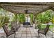 Covered patio with outdoor seating and tropical foliage, perfect for relaxation and entertaining at 113 16Th St, Belleair Beach, FL 33786
