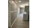 Hallway with stackable washer and dryer and wood-look flooring at 11351 Edison Ave, New Port Richey, FL 34654