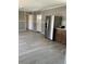 View of the living room and kitchen with gray walls and wood-look flooring at 11351 Edison Ave, New Port Richey, FL 34654