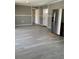 View of the living room and kitchen with gray walls and wood-look flooring at 11351 Edison Ave, New Port Richey, FL 34654
