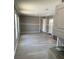 View of the living room and kitchen with gray walls and wood-look flooring, stackable washer/dryer at 11351 Edison Ave, New Port Richey, FL 34654