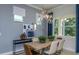Inviting dining area with modern light fixtures, a wooden table, and large windows providing natural light at 11443 Shoreline Trl, Parrish, FL 34219