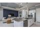A modern open-concept kitchen boasts a spacious island, stainless steel appliances, and stylish pendant lighting at 11443 Shoreline Trl, Parrish, FL 34219