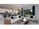 Bright living room with couches, modern lighting, and a large sliding glass door showcasing the backyard at 11443 Shoreline Trl, Parrish, FL 34219