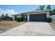 Charming one-story home featuring a dark gray two car garage and well-maintained landscaping at 12456 Spreading Oak Dr, Spring Hill, FL 34609