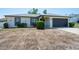 Charming one-story home featuring a dark gray two car garage and minimal landscaping at 12456 Spreading Oak Dr, Spring Hill, FL 34609