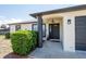 View of the home's front door with decorative shrubbery at 12456 Spreading Oak Dr, Spring Hill, FL 34609