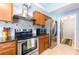 Modern kitchen showcasing stainless steel appliances, granite countertops, tile backsplash, and dark wood cabinets at 12456 Spreading Oak Dr, Spring Hill, FL 34609
