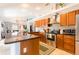 Open kitchen features stainless steel appliances, granite countertops, and wood cabinetry with access to the living room at 12456 Spreading Oak Dr, Spring Hill, FL 34609