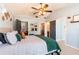 Bright main bedroom showcasing a ceiling fan, carpeted floors, and views to the ensuite and closet at 12456 Spreading Oak Dr, Spring Hill, FL 34609