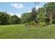 Lush backyard featuring mature landscaping, a bench, and a variety of tropical trees at 13813 Sigler St, Riverview, FL 33579
