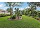 Lush green lawn in a serene backyard setting, adorned with tropical landscaping and mature trees at 13813 Sigler St, Riverview, FL 33579