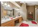 Large bathroom features double vanity, mirrors, stylish wallpaper, and tile floors at 13813 Sigler St, Riverview, FL 33579