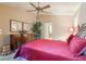 Bright bedroom with large dresser, ceiling fan, warm paint, and king-size bed with an eye-catching red bedspread at 13813 Sigler St, Riverview, FL 33579