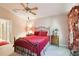 Cozy bedroom features a red-themed decor, including a bed with wrought-iron frame and floral window coverings at 13813 Sigler St, Riverview, FL 33579