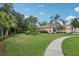 Well-manicured front yard with vibrant green grass, a curving sidewalk, and mature palm trees enhancing curb appeal at 13813 Sigler St, Riverview, FL 33579