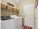 Functional laundry room with washer, dryer, and storage shelves at 13813 Sigler St, Riverview, FL 33579