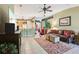 Open-concept living room featuring tile flooring, ceiling fan, and a comfortable leather sofa at 13813 Sigler St, Riverview, FL 33579