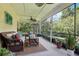 Inviting screened-in patio with comfortable wicker furniture, ceiling fan, and view of the lush backyard at 13813 Sigler St, Riverview, FL 33579