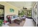 Inviting sunroom features comfortable wicker seating, a ceiling fan, and screened windows with peaceful views at 13813 Sigler St, Riverview, FL 33579