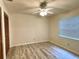 Bedroom with a ceiling fan, closet and light-filled window with blinds, plus wood-look floors at 16517 Norwood Dr, Tampa, FL 33624
