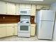 Bright kitchen area with white oven, microwave, and refrigerator complemented by light cabinetry at 16517 Norwood Dr, Tampa, FL 33624
