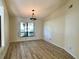 Spacious living room featuring wood flooring, a window, and a unique ceiling light fixture at 16517 Norwood Dr, Tampa, FL 33624