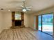 Living room with sliding glass doors to the pool, modern floors, and a stone fireplace at 16517 Norwood Dr, Tampa, FL 33624