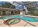 Screened-in pool and spa surrounded by lounge chairs and outdoor dining space at 16517 Norwood Dr, Tampa, FL 33624