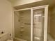 Enclosed shower featuring a grab bar, multiple shelves, and clear glass door at 16517 Norwood Dr, Tampa, FL 33624