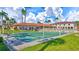 Community shuffleboard courts with lush landscaping and beautiful buildings under a partly cloudy blue sky at 19029 Us Highway 19 N # 2-23, Clearwater, FL 33764