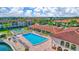 Aerial view of the community pool, clubhouse, tennis court, and surrounding condos at 19029 Us Highway 19 N # 2-23, Clearwater, FL 33764