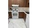 Kitchen featuring wood cabinets, white appliances, and marble-look flooring at 19029 Us Highway 19 N # 2-23, Clearwater, FL 33764