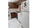 Kitchen featuring wood cabinets, white appliances, and marble-look flooring at 19029 Us Highway 19 N # 2-23, Clearwater, FL 33764