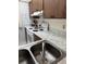 Galley kitchen featuring wood cabinets, white appliances, and marble-look countertops at 19029 Us Highway 19 N # 2-23, Clearwater, FL 33764