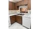 Kitchen featuring wood cabinets, white appliances, and marble-look countertops at 19029 Us Highway 19 N # 2-23, Clearwater, FL 33764