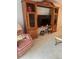 Living room with plush armchair, wooden entertainment center, and adjacent side table at 19029 Us Highway 19 N # 2-23, Clearwater, FL 33764