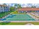 Well-maintained shuffleboard courts with palm trees and community buildings in the background at 19029 Us Highway 19 N # 2-23, Clearwater, FL 33764