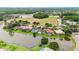 Aerial view of luxury homes with tile roofs and pools, nestled along a picturesque lake and landscape at 19107 Avenue Bayonnes, Lutz, FL 33558