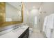 Modern bathroom featuring a sleek glass shower, dark wood vanity, and gold-framed mirror at 19107 Avenue Bayonnes, Lutz, FL 33558