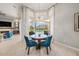 Bright dining area features modern chandelier, blue chairs, and views of the pool area through large windows at 19107 Avenue Bayonnes, Lutz, FL 33558