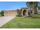 Exterior of home showcasing the arched entry, well-maintained lawn and lush landscaping at 19107 Avenue Bayonnes, Lutz, FL 33558
