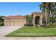 Exterior of a beautiful home featuring a three-car garage, arched entry, and landscaped front yard at 19107 Avenue Bayonnes, Lutz, FL 33558
