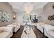 Spacious living room with elegant seating, dark wood floors, and ornate chandeliers, ideal for gatherings at 19107 Avenue Bayonnes, Lutz, FL 33558